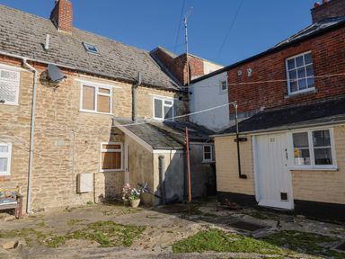 An outdoor area with buildings and a flower pot at Rope Cottage in Bridport