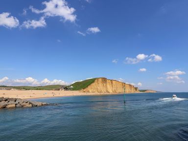 A beach with cliffs and water at Rope Cottage in Bridport