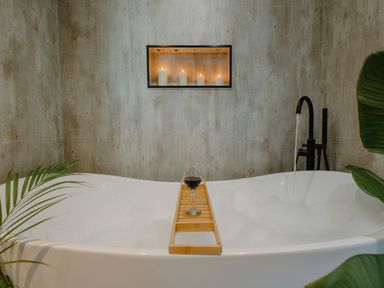 A bathroom with a bathtub and candles in a display at The Elton in Kings Cliffe