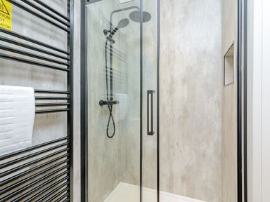 A shower with glass doors and towel rack at The Elton in Kings Cliffe