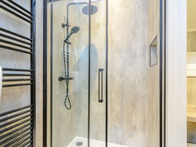 A shower with glass door and towel rack at The Castor in Kings Cliffe