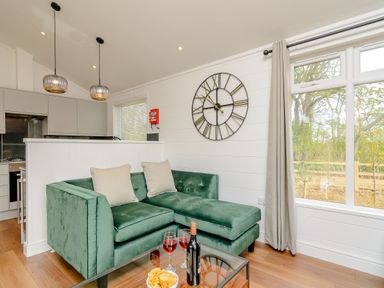 A living room with a green sofa and table at The Castor in Kings Cliffe
