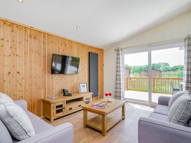 A living room with a television and sofa at The Kingscliffe (Pet) in Kings Cliffe
