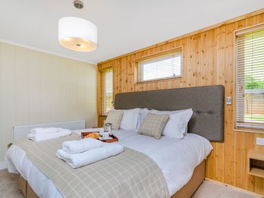 A bedroom with a bed and windows at The Kingscliffe (Pet) in Kings Cliffe