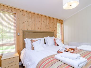 A bedroom with a bed and nightstand at The Sutton in Kings Cliffe