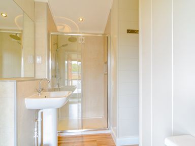 A bathroom with a shower and wash basin at The Sutton in Kings Cliffe