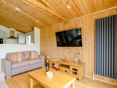 A living room with a sofa and television at The Sutton (Pet) in Kings Cliffe