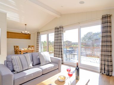 A living room with a sofa and dining table at The Chesterton (Pet) in Kings Cliffe