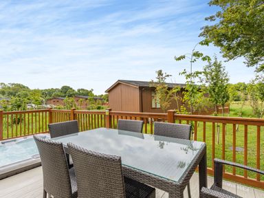 A dining table with chairs on a deck at The Nassington (Pet) Kings Cliffe