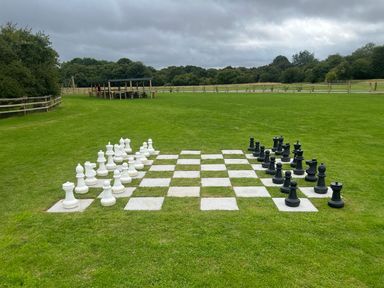 An outdoor chessboard with large black and white pieces at The Wansford in Kings Cliffe