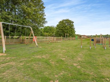 A playground with swing set and equipment at The Wansford in Kings Cliffe