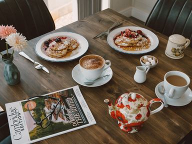 A dining table with pancakes, coffee, and a teapot at The Wansford in Kings Cliffe