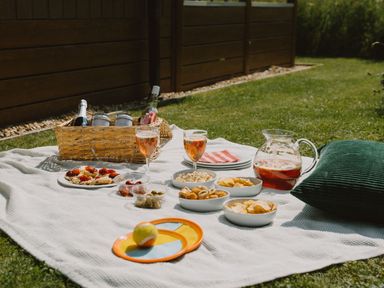 A picnic setup with food and drinks on a blanket at The Wansford in Kings Cliffe