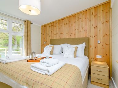 A bedroom with a bed and bedside table at The Wansford (Pet) in Kings Cliffe
