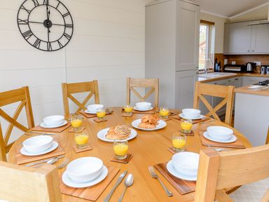 A dining room with a round table set for breakfast at The Ailsworth (Pet) Kings Cliffe