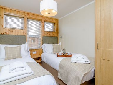 A bedroom with two beds and a tray with cups at The Ailsworth (Pet) in Kings Cliffe