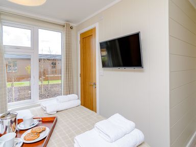 A bedroom with towels and refreshments on a tray at The Ailsworth (Pet) Kings Cliffe