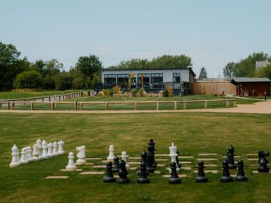 An outdoor area with large chess pieces and a building at The Ailsworth (Pet) in Kings Cliffe