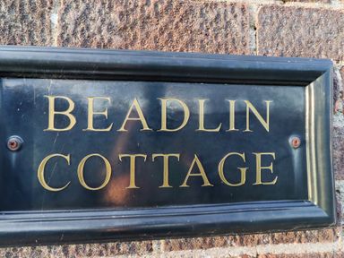 A plaque with the words Beadlin Cottage at Beadlin cottage Beadnell