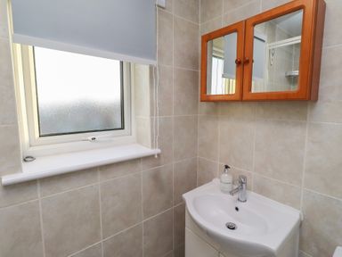 A bathroom with a sink and mirror at Beadlin cottage Beadnell