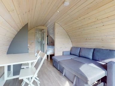 A living room with a sofa, table, and shower at Pod 1 (Pet Friendly) in Carnforth