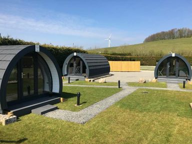 An outdoor area with cabins and a wind turbine at Pod 1 (Pet Friendly) in Carnforth