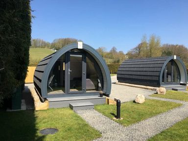 Two cabins with rounded roofs in an outdoor area at Pod 1 (Pet Friendly) Carnforth