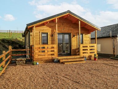 A log cabin with steps and gravel area at Glenview Log Cabin in Ballycastle