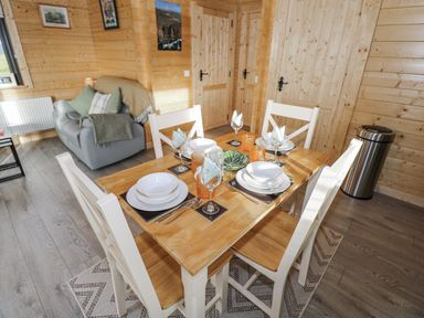 A dining room with a table and chairs at Glenview Log Cabin Ballycastle