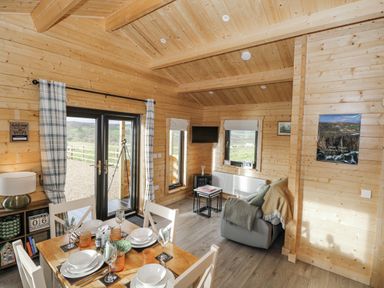 A living room with a dining table and chairs at Glenview Log Cabin in Ballycastle