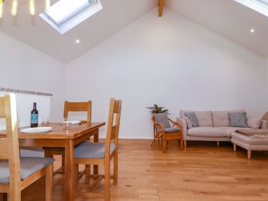 A living room with a table, chairs, and a couch at The Maisonette in Hayle
