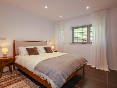 A bedroom with a bed and side tables at The Maisonette in Hayle