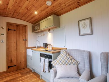 A kitchen with wooden door and table at Dave’s Place in Broadstone near Munslow