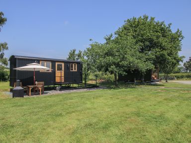 A cabin with a patio and furniture in an outdoor area at Dave’s Place Broadstone near Munslow