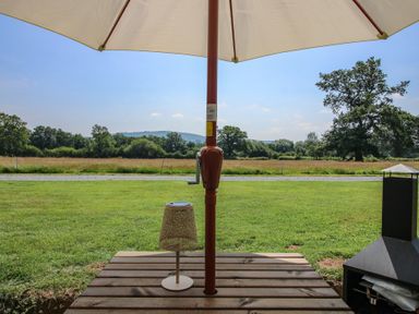 An outdoor area with an umbrella and a lamp at Dave’s Place Broadstone near Munslow