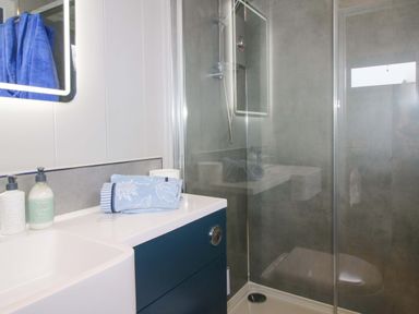 A bathroom with a shower and sink at Leafy Oak Lodge in Munslow