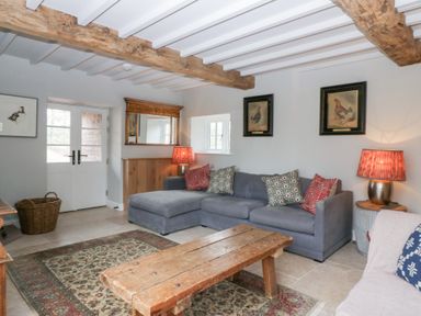 A living room with a sofa and coffee table at Velindra Farm Cottage in Hereford