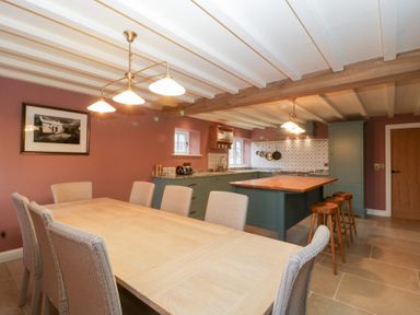 A kitchen with a dining table and chairs at Velindra Farm Cottage Hereford