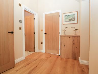 A hallway with wooden doors and a console table at Velindra Farm Cottage Hereford