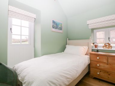 A bedroom with a bed and chest of drawers at Velindra Farm Cottage Hereford