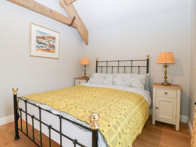 A bedroom with a bed and nightstands at Velindra Farm Cottage Hereford