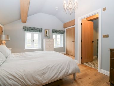 A bedroom with a bed and chest of drawers at Velindra Farm Cottage Hereford