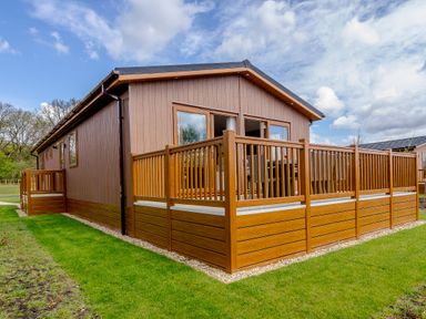 An outdoor cabin with a deck and fenced area at The Alwalton in Kings Cliffe