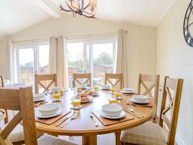 A dining room with a round table and plates at The Alwalton in Kings Cliffe