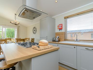 A kitchen with an island, gas stove, and sink at The Alwalton in Kings Cliffe