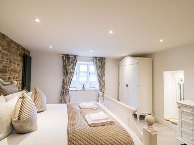 A bedroom with a bed and wardrobe at Lake View in Crediton