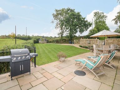 A garden with a grill and seating area at Lake View in Crediton