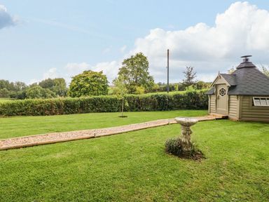 A garden with a gravel path and a wooden garden shed at Lake View in Crediton