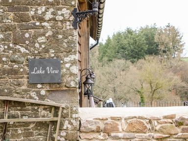 A stone wall with a Lake View sign and lantern at Lake View in Crediton