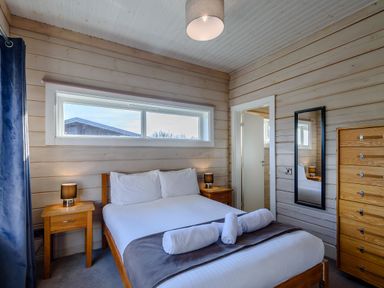 A bedroom with a bed and furniture at Chestnut Spa Carlton Miniott near Thirsk